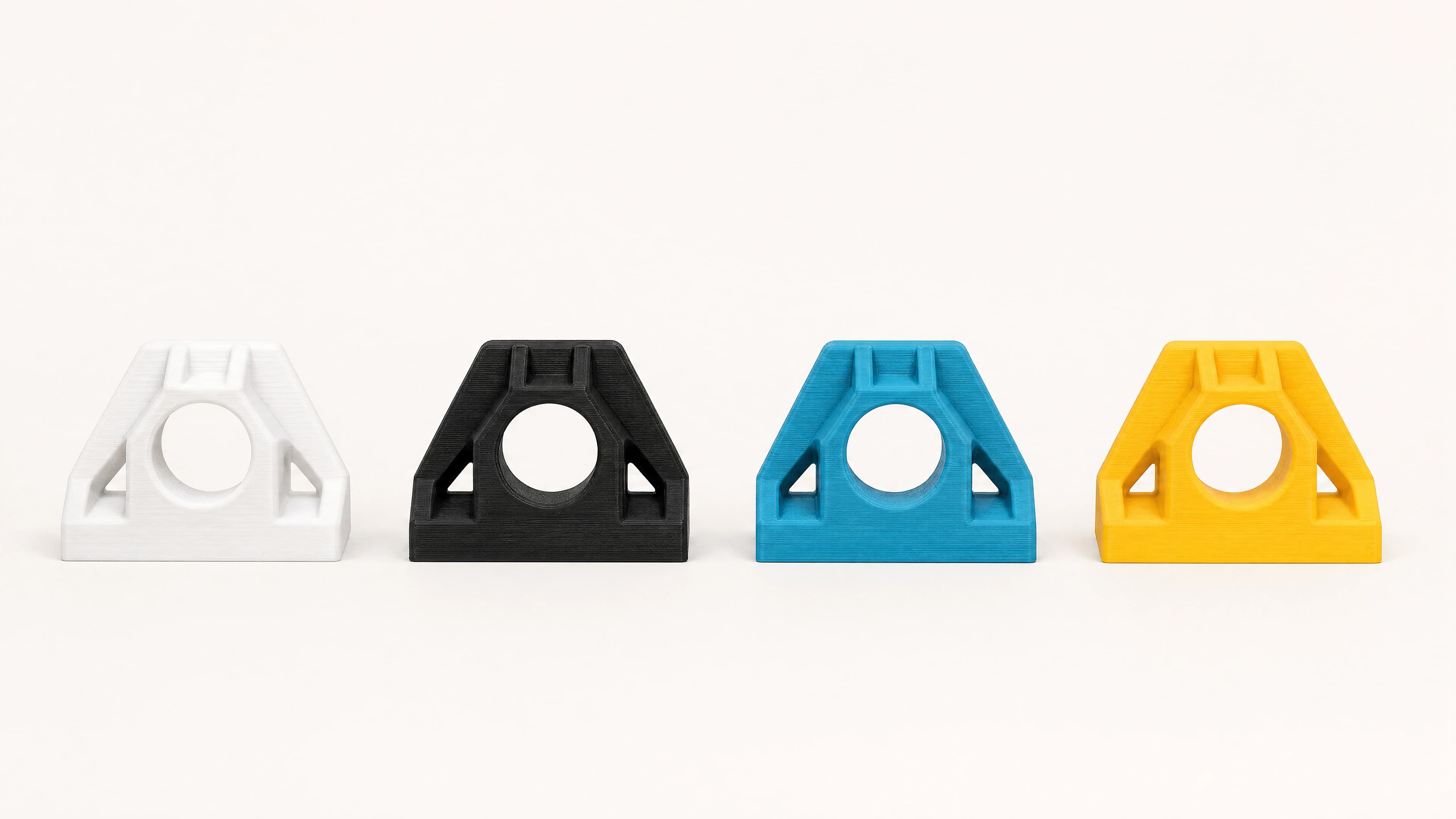 Four matching FDM-printed samples in white, black, blue and yellow.